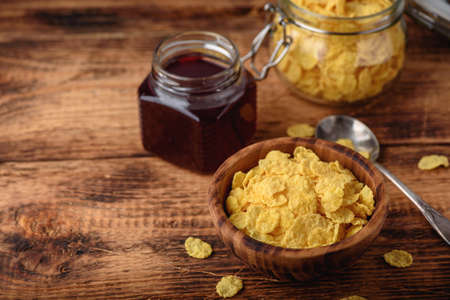 Breakfast with corn flakes, milk and berry jam