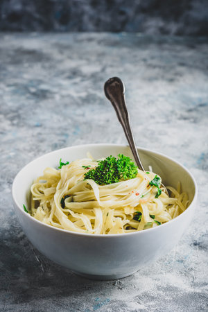 Easy lunch recipe. Linguine pasta with olive oil, garlic, fresh parsley and grated parmesan cheese.の写真素材