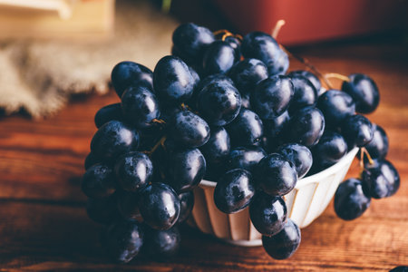 Close Up of Dark Blue Grapes in a Vintage Bowl on Wooden Table