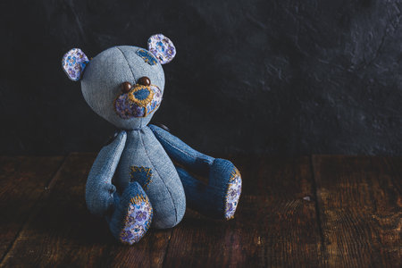 Blue Handmade Bear Toy Sitting on Wooden Surfaceの写真素材
