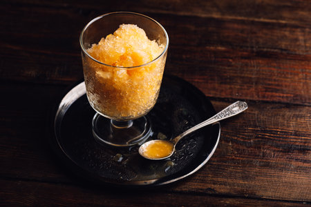 Portion of Homemade Yellow Watermelon Granita on Rustic Tableの写真素材