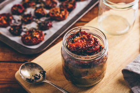Freshly Prepared Sun Dried Tomatoes with Olive Oil and Herbs in a Glass Jarの写真素材
