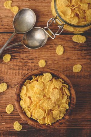 Corn flakes in a wooden bowl for breakfast. View from aboveの写真素材