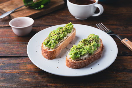 Toasts with mashed avocado and cream cheese and cup of black coffee