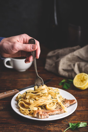 Pork chop steak and tagliatelle with capers and lemon zestの写真素材