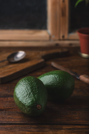 Two whole avocados with knife on rustic tableの写真素材