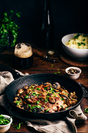 Fried pork neck steak with different mushrooms and mashed potatoesの写真素材