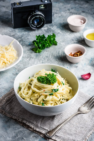 Easy lunch recipe. Linguine pasta with olive oil, garlic, fresh parsley and grated parmesan cheese.の写真素材