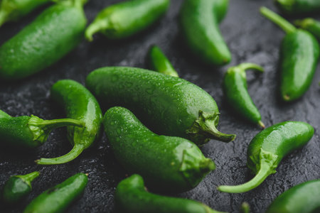 Close Up of Green Jalapeno Peppers on Dark Concrete Backgroundの写真素材