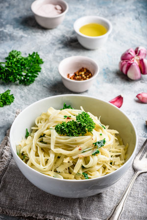 Easy lunch recipe. Linguine pasta with olive oil, garlic, fresh parsley and grated parmesan cheese.の写真素材