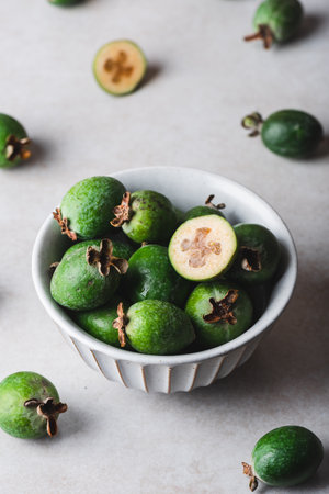 Feijoa fruit in a vintage bowl on a light concrete backgroundの写真素材