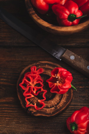 Still Life of Red Habanero Chili Peppers and One Sliced on a Dark Wooden Backgroundの写真素材