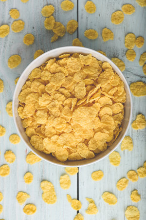 White bowl of corn flakes on a wooden surfaceの写真素材