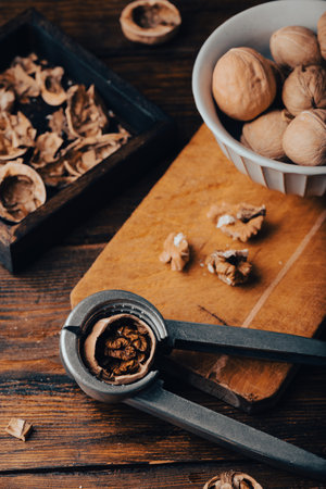 Walnuts and nutcracker on wooden surfaceの写真素材