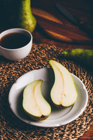 Halved Conference Pear on White Plateの写真素材