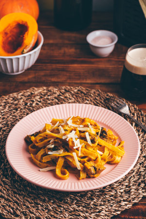 Tagliatelle Pasta with Creamy Pumpkin Sauce and Champignons Garnished with Grated Parmesan Cheeseの写真素材
