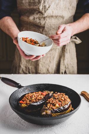 Preparing eggplants stuffed with ground beef, tomatoes and spices. Traditional dish Karniyarik of Turkish cuisineの写真素材