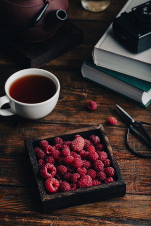 Cup of tea with ripe raspberries on a wooden tableの写真素材