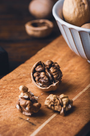 Cracked walnuts and nutcracker on cutting boardの写真素材
