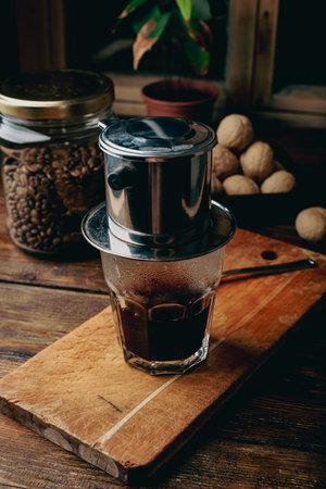 Coffee brewing in traditional Vietnamese coffee drip filter on wooden backgroundの写真素材