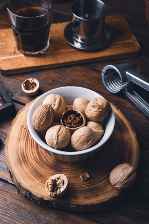 Bowl full of walnuts and nutcracker on wooden tableの写真素材