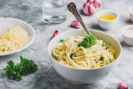 Easy lunch recipe. Linguine pasta with olive oil, garlic, fresh parsley and grated parmesan cheese.の写真素材