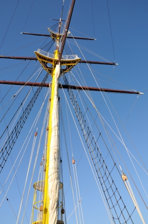 Mainmast of big sailboat with blue sky in background