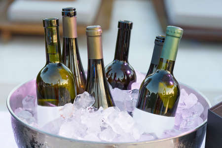 White wine bottles in bowl of iceの写真素材