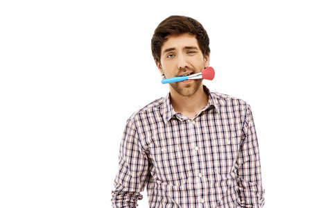 Close-up portrait of handsome young blue-eyed dark-haired man with brush wearing casual plaid shirt. Isolated.の写真素材