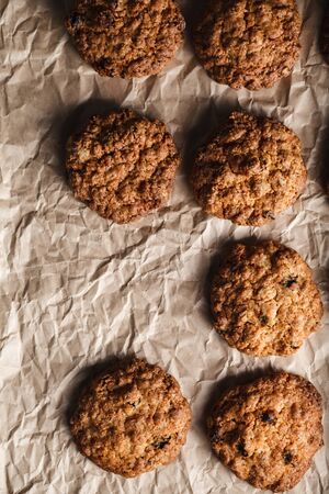 Close-up image of oatmeal cookies with nuts on a baking tray with parchment paperの写真素材