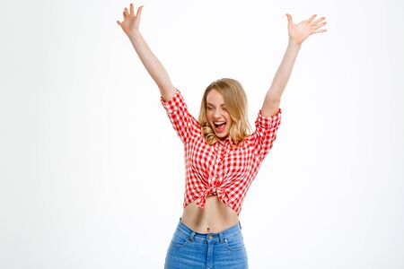 Portrait of young beautiful country girl in jeans and shirt smiling, rejoicing over white background.の写真素材