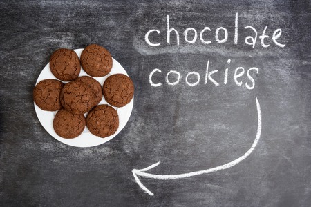 Sweet chocolate cookies  in plate on wooden tableの写真素材