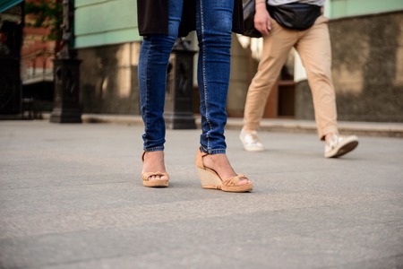 Close up photo of couple's legs in keds walking down street. Copy space.の写真素材