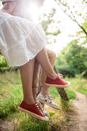 Close up photo of couple in keds sitting on bench. Copy space.の写真素材