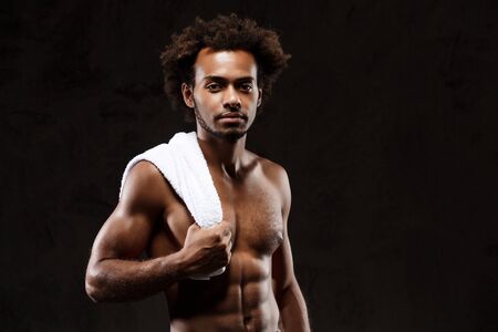 Young sportive african handsome  man posing over black background. Copy space.の写真素材