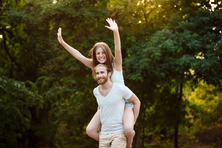 Young beautiful couple resting, walking in park, smiling, rejoicingの写真素材