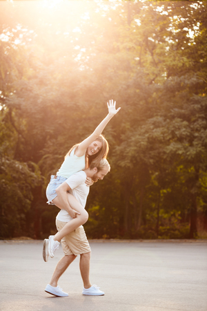 Young beautiful couple resting, walking in park, smiling, rejoicingの写真素材