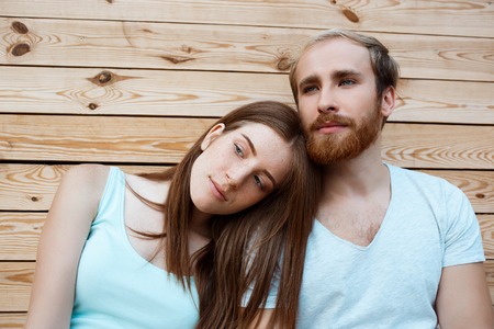 Young beautiful couple smiling, posing, wooden boards backgroundの写真素材