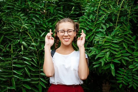 Young beautiful female student hoping, posing in leaves outdoors.の写真素材