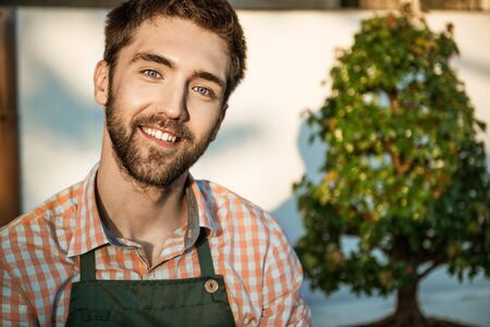 Young handsome gardener smiling, looking at camera, posingの写真素材