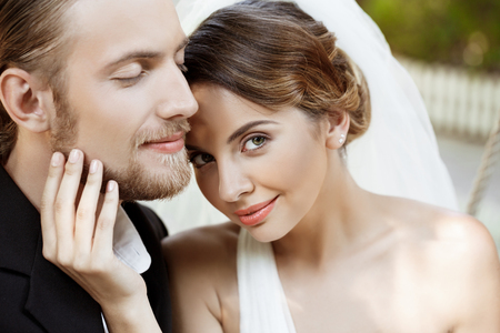 Happy beautiful newlyweds in suit and wedding dress smiling, enjoying. Copy space.の写真素材