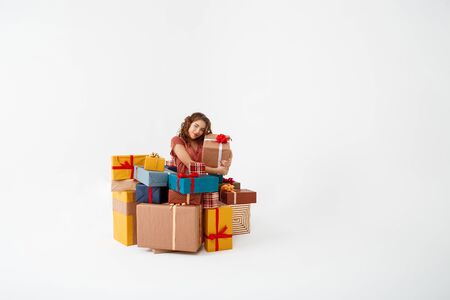 Young beautiful curly girl among gift boxes Isolated Copy spaceの写真素材