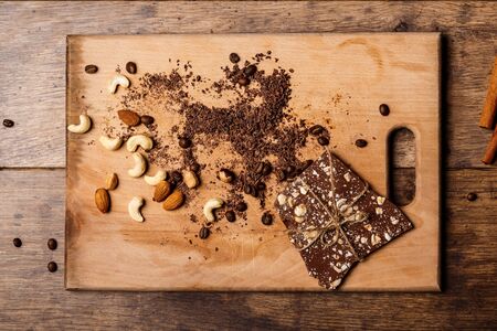 Chocolate candies cinnamon and nuts over wooden background. From above. Copy space.の写真素材
