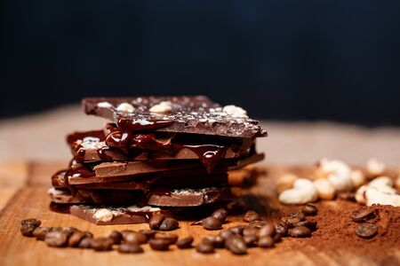 Chocolate and nuts over black background. Copy space.