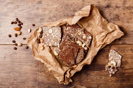 Chocolate and nuts over wooden background. From above. Copy space.の写真素材