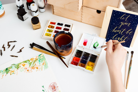 Girl painting flowers on paper with watercolor. Copy space. Art design.の写真素材