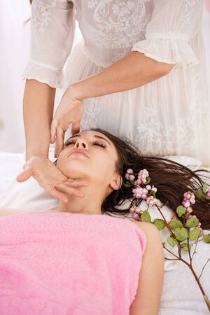 Closeup of female masseur hands doing facial massage carefullyの写真素材