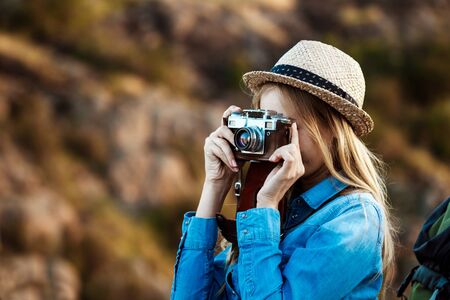 Beautiful blonde female photographer taking picture of canyon landscape.の写真素材