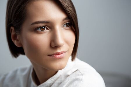 Portrait of young beautiful brunette girl smiling over white background.の写真素材