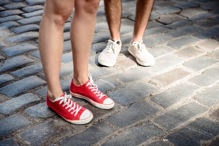 Close up of couples legs in keds standing at street.の写真素材